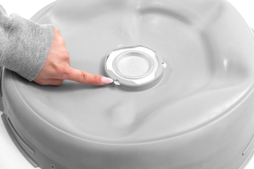 Weight retainer installed with a finger pointing to tab