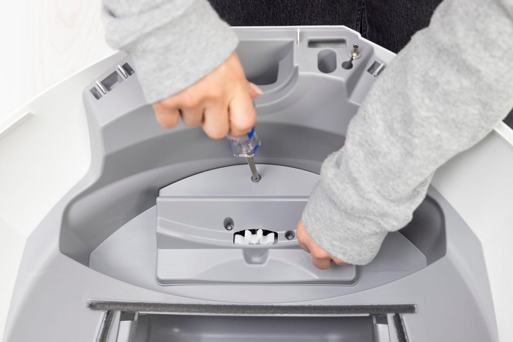 Motor cover being installed with Philips screwdriver