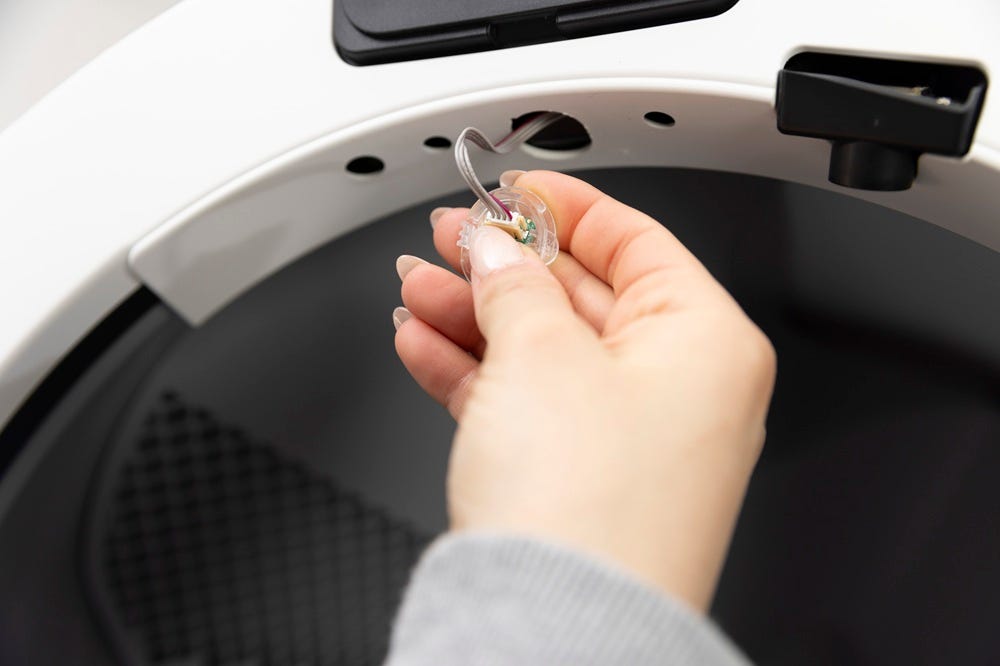 Plastic connector being held in one hand and the sensor in another hand