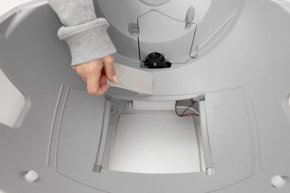 Litter-Robot base with seal strips removed and duct tape pulling away from the base